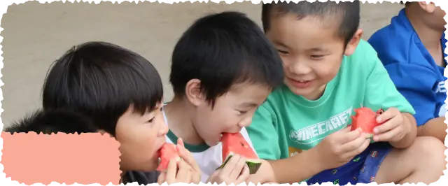 スイカを食べながら笑い合う3人の男の子