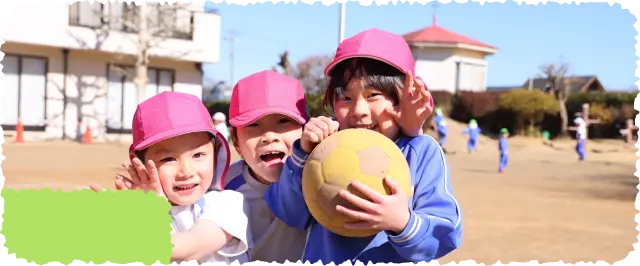 年長の男の子2人とボールを持った女の子1人が肩を組み、笑顔でカメラを見ている様子
