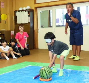 目隠しをしてスイカ割りをする男の子