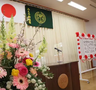 ホールに生花と式次第が飾られた入園式の様子