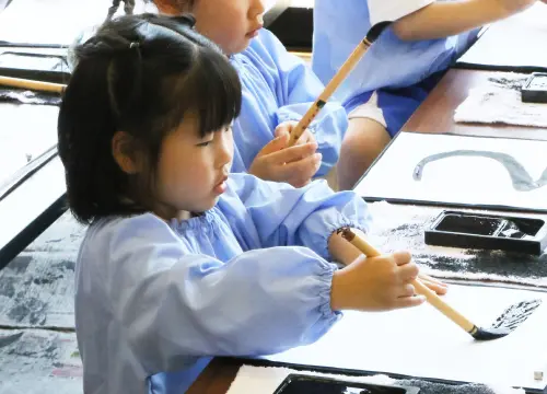 書道で文字を学ぶ女の子