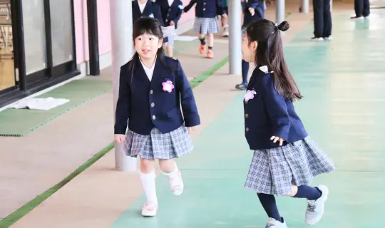 幼稚園の制服を着て登園する女の子2人